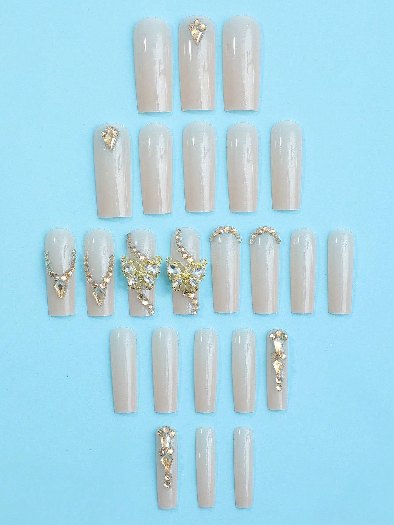 Elegant 24-piece XL square press-on nails in a glossy nude finish with gold and rhinestone embellishments, perfect for a luxurious manicure upgrade.