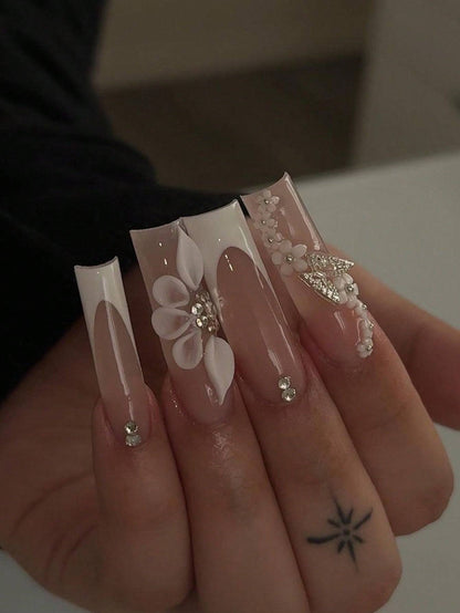 Elegant 24-Piece XL Square Press-On Nails featuring a nude and white design with intricate 3D floral accents, rhinestones, and a glossy finish for a luxurious manicure.