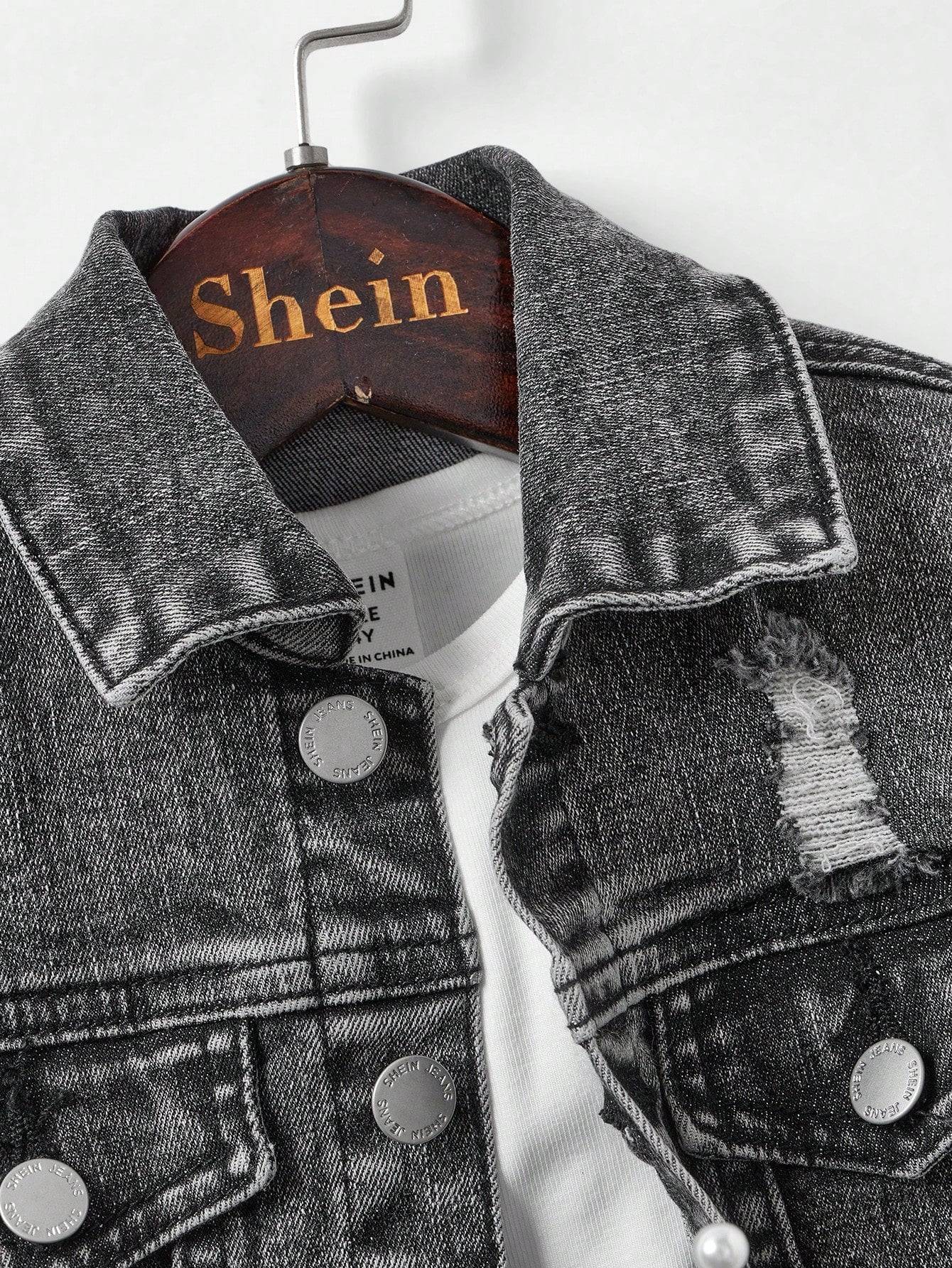 Close-up of kids' black denim jacket with distressed details and silver buttons, highlighting its stylish and rugged design.