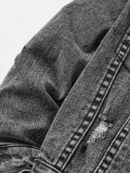 Detailed view of the distressed fabric on the kids' black denim jacket, emphasizing its trendy and worn-in look.