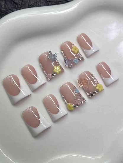 Set of Y2K Duck Nail Tips with floral and rhinestone accents. The fake nails showcase a nude and white color scheme with intricate 3D decorations.