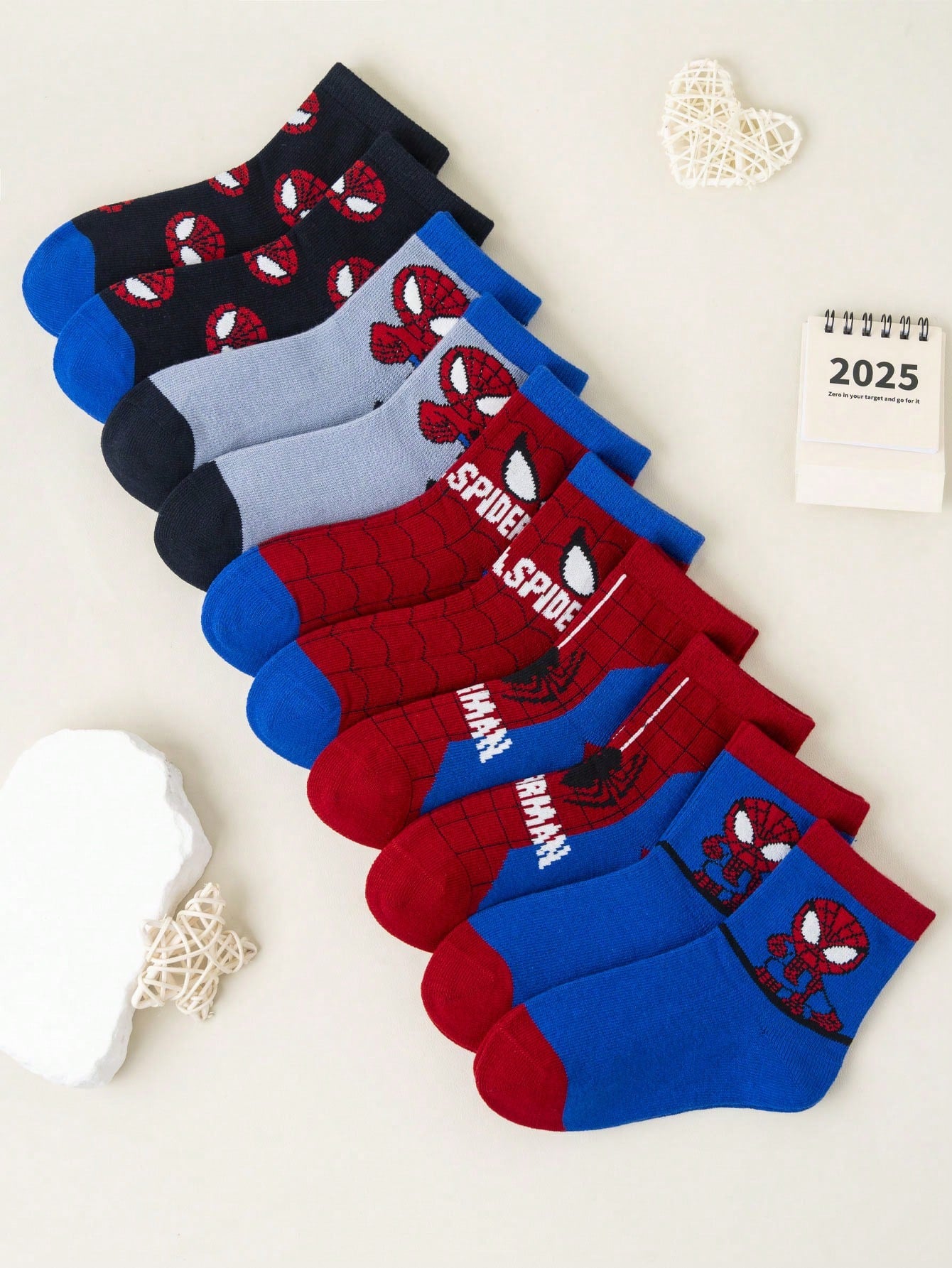 Five pairs of Spider-Man socks displayed on a red and blue background, featuring bold superhero graphics. Soft, breathable fabric ensures comfort.